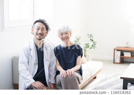 一位醫生和一位老年患者來家中看著鏡頭的照片 一位醫生和一位老年患者來家中看著鏡頭的照片 116019262
