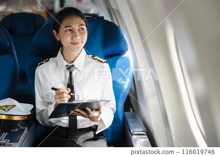 Portrait of a trained airplane captain in uniform preparing to fly, event planning sitting in airplane. Portrait of a trained airplane captain in uniform preparing to fly, event planning sitting in airplane. 116019746