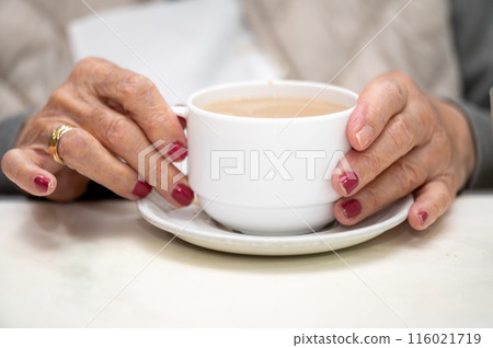 Close up of elderly woman enjoying breakfast 116021719
