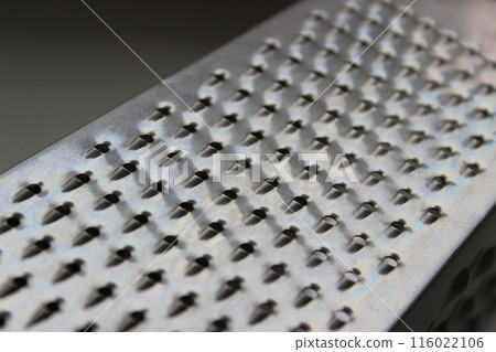 Closeup view of one of the sides of a square kitchen cheese grater Closeup view of one of the sides of a square kitchen cheese grater 116022106