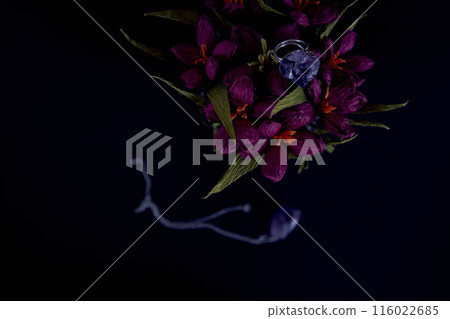 amethyst ring and a pendant of paper flowers in a blue vase on a black background amethyst ring and a pendant of paper flowers in a blue vase on a black background 116022685