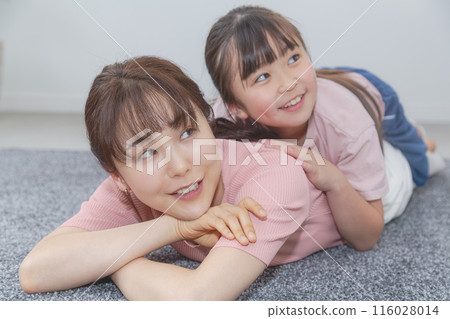 Daughter playing on mom's back Daughter playing on mom's back 116028014