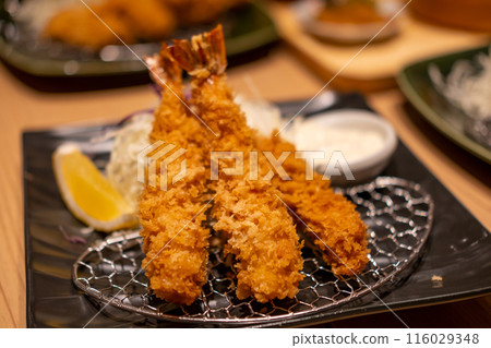 Fried shrimp served on plate with lemon in the restaurant Fried shrimp served on plate with lemon in the restaurant 116029348