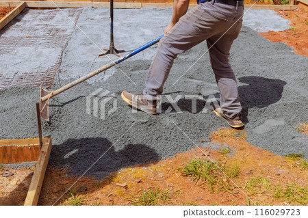 Construction work involves leveling ground, filling it with fine gravel stones, before pouring concrete into foundation of house Construction work involves leveling ground, filling it with fine gravel stones, before pouring concrete into foundation of house 116029723