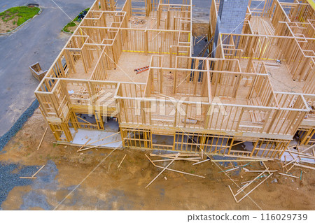 In construction, wooden beams are being used for framing roof wall of new home that is under construction 116029739