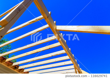 As part of remodeling house construction improvement, installing framing beams wood trusses into an unfinished floor As part of remodeling house construction improvement, installing framing beams wood trusses into an unfinished floor 116029741