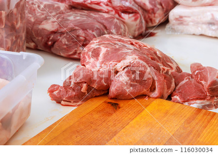 Raw pork meat is marinated a prepared for grilling on barbecue BBQ 116030034