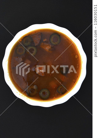 Meat solyanka. Meat soup in a white plate. 116030151