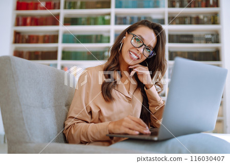 Happy young woman relaxing in Coworking space using laptop.Education concept. Business, online. Happy young woman relaxing in Coworking space using laptop.Education concept. Business, online. 116030407