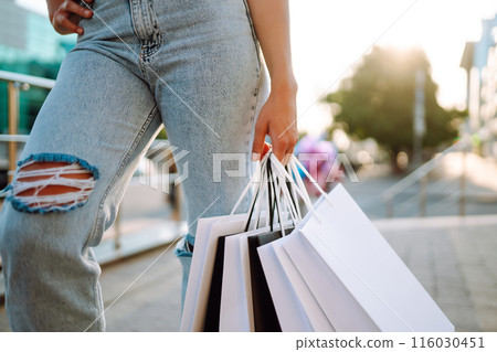 Young woman with shopping goes from mall. Summer shopping. Concept of lifestyle, shopping, selling. 116030451