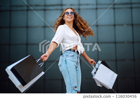 Woman in shopping. Woman with shopping bags walking around city after shopping. Lifestyle concept. Woman in shopping. Woman with shopping bags walking around city after shopping. Lifestyle concept. 116030456