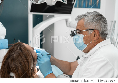 A dentist and an assistant, working as a team, guarantee the best result for the patient. Their cohesion and mutual assistance is an important element of successful treatment. A dentist and an assistant, working as a team, guarantee the best result for the patient. Their cohesion and mutual assistance is an important element of successful treatment. 116030597