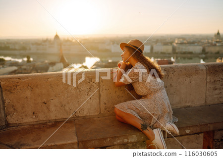 Young female tourist looking at panoramic view of the city at sunset. Lifestyle, travel, active life Young female tourist looking at panoramic view of the city at sunset. Lifestyle, travel, active life 116030605