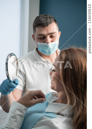 In a dental clinic, the patient rests in a chair, looks in the mirror at the result of work and dental treatment, relying on the experience and qualifications of the doctor who performs the treatment. In a dental clinic, the patient rests in a chair, looks in the mirror at the result of work and dental treatment, relying on the experience and qualifications of the doctor who performs the treatment. 116030610