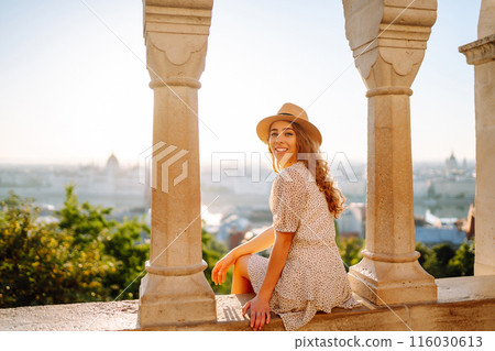 Young female tourist enjoys the view of the city at sunset. Travel and tourism concept. Young female tourist enjoys the view of the city at sunset. Travel and tourism concept. 116030613