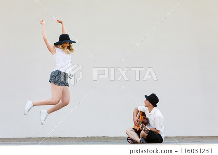 Man playing guitar, woman having fun Man playing guitar, woman having fun 116031231