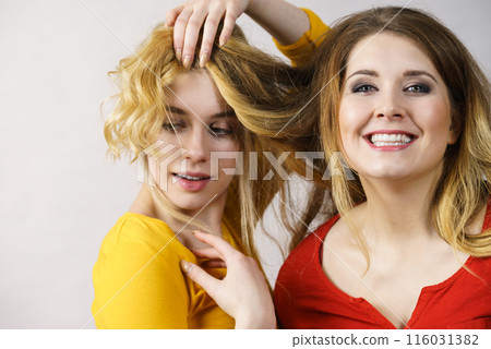 Two girls creating hairdo. Hair ombre color 116031382