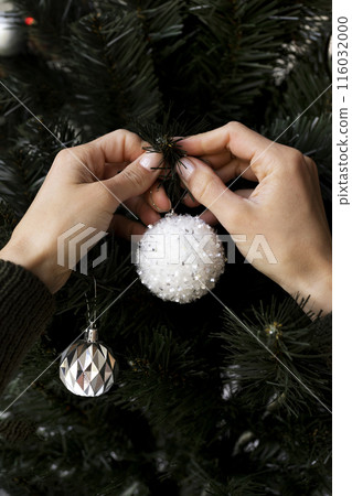 close up hands decorating christmas tree 116032000