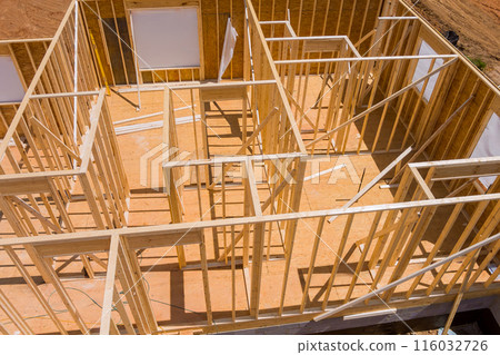 Framing of new unfinished residential home under construction is made up wood supports beam Framing of new unfinished residential home under construction is made up wood supports beam 116032726