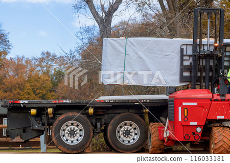 Using forklift on construction site to deliver building materials 116033181