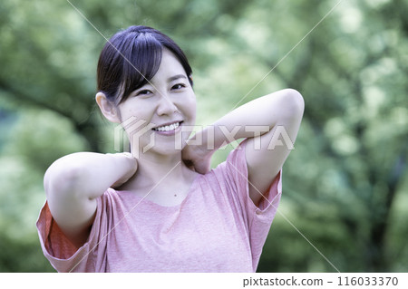 一個女人在新鮮的綠色植物中伸展身體 116033370