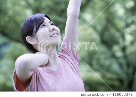 一個女人在新鮮的綠色植物中伸展身體 116033371