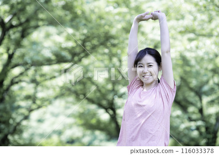 A woman stretching in the fresh greenery 116033378