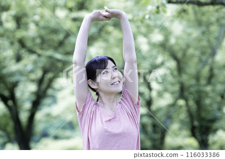 一個女人在新鮮的綠色植物中伸展身體 116033386