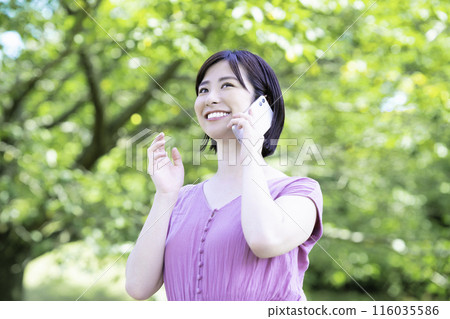 一位女士在清新的綠色公園打電話給智慧型手機 116035586