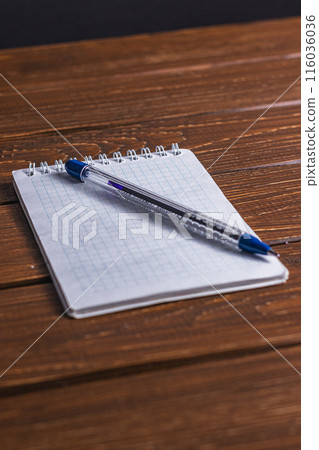 office notebook and pen on a brown table 116036036