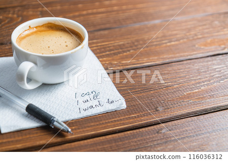 Hand written note on a coffee stained napkin with an empowe 116036312