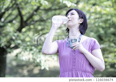 一個女人在新鮮的綠色公園補水 116036674