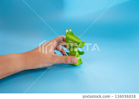 easy paper craft for kids, handmade finger toy made from recycled materials. Green crocodile with visible teeth and spikes, eco-friendly and fun. Perfect for children's art projects and creative play 116036838