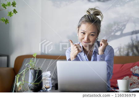 mature asian woman working from home video chatting using laptop computer mature asian woman working from home video chatting using laptop computer 116036979