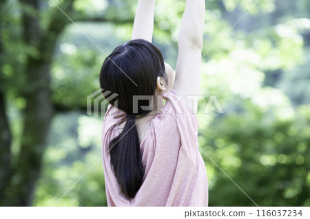 一個女人在新鮮的綠色植物中伸展身體的後視圖 一個女人在新鮮的綠色植物中伸展身體的後視圖 116037234