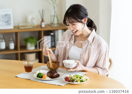 Young woman eating lunch at home 116037416