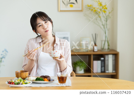 Young woman eating lunch at home 116037420