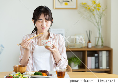Young woman eating lunch at home 116037421