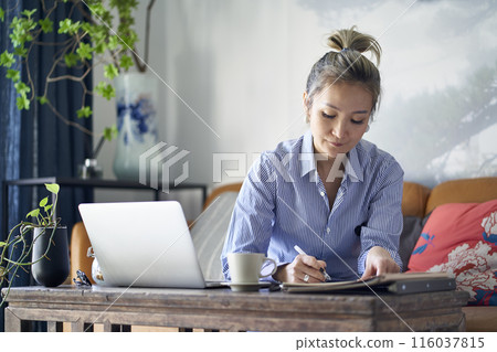 mature asian woman working from home using notebook computer 116037815