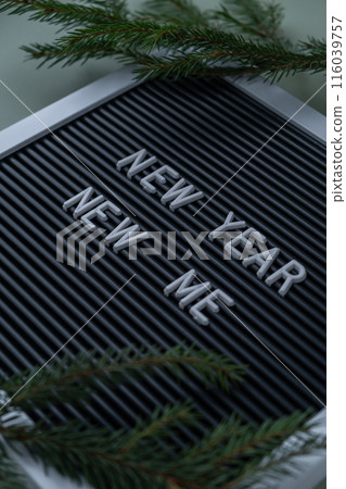 NEW YEAR NEW ME text on black letter board on green background with Christmas decor. New year aims resolutions. Planning and setting goals NEW YEAR NEW ME text on black letter board on green background with Christmas decor. New year aims resolutions. Planning and setting goals 116039757