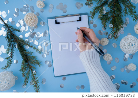 Woman writing letter to SANTA or promises and aims. Empty notebook Preparation for new year. Visualizing wish list for 2025. Dreams plan action resolutions for coming year. Inspirational self 116039758