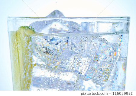 Glass of carbonated water with ice and lime 116039951