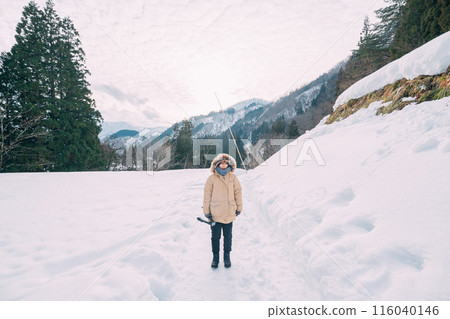 A girl walking in the snow 116040146
