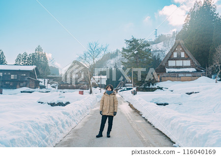 A woman walking through a snowy rural landscape A woman walking through a snowy rural landscape 116040169