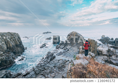 Man looking at the sea from a cliff 116040172