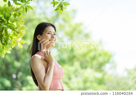 Woman doing yoga in green park (outdoor portrait, relaxing) 116040284