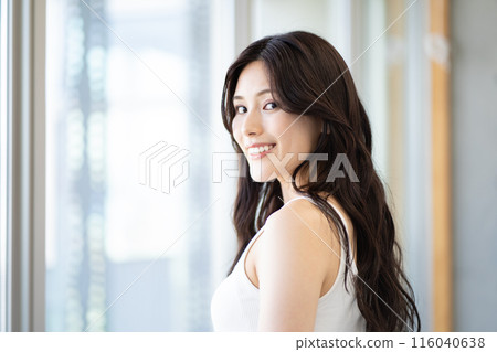 Young woman with long black hair (beauty image, white sleeveless, window, natural light) 116040638