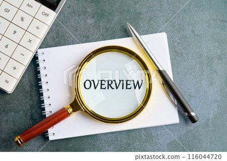 Conceptual overview word symbol. Copy space. Overview word written through a magnifying glass in a notebook on a gray background 116044720