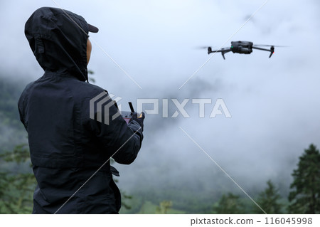 Flying drone in high altitude mountains Flying drone in high altitude mountains 116045998