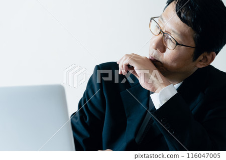 A businessman worried in front of a computer 116047005